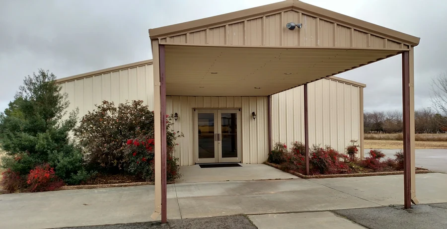 The sheltered doorway at Skyline Missionary Baptist Church, with red shrubs beside the entrance.